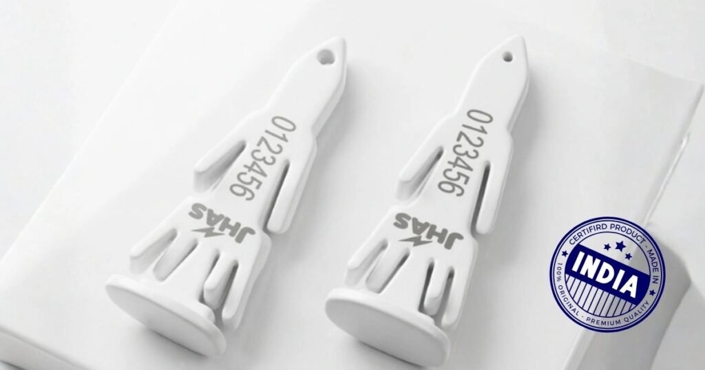 Two white plastic devices with numbered markings lie on a white surface, next to a blue India certification stamp.